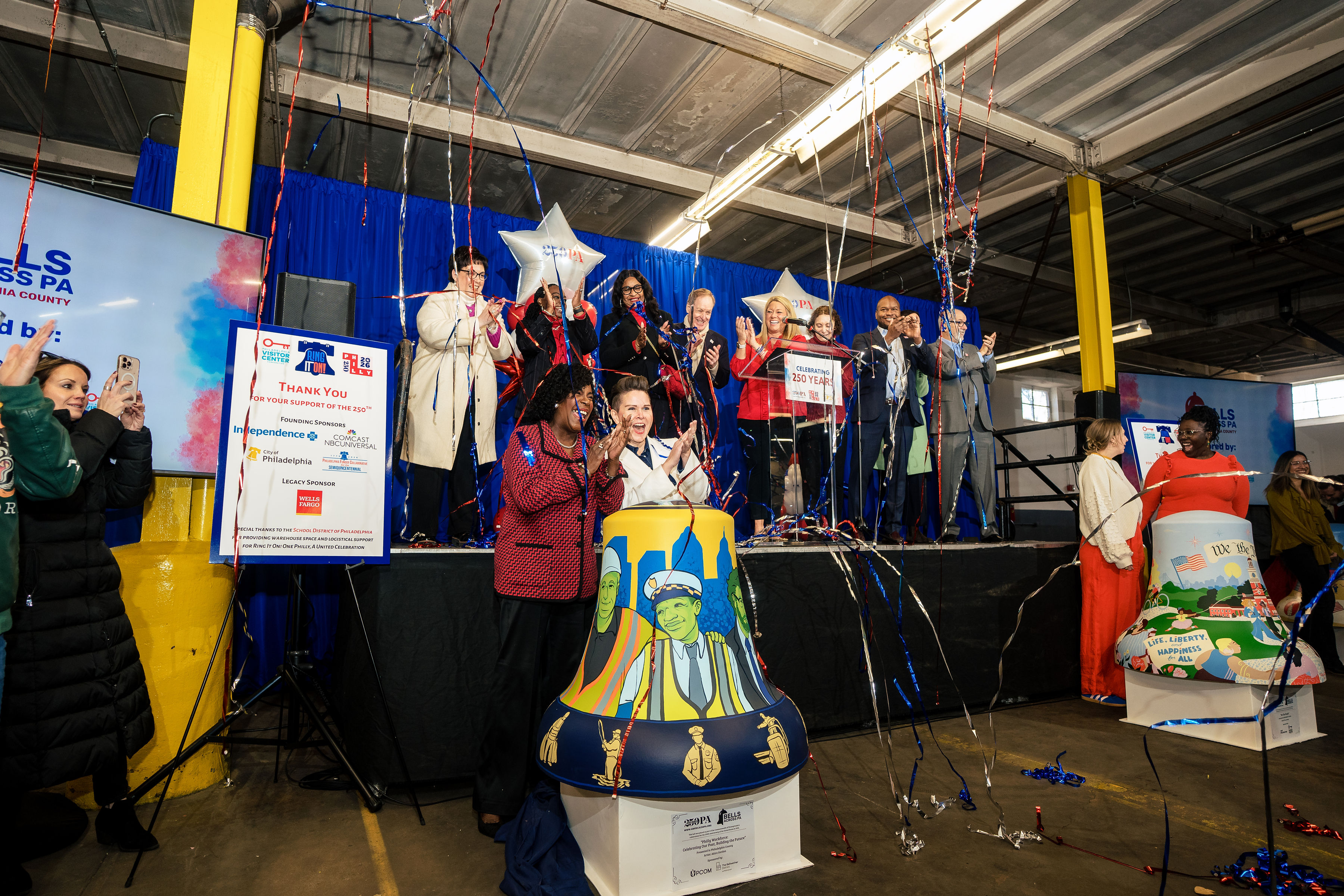 people on stage clapping as confetti falls