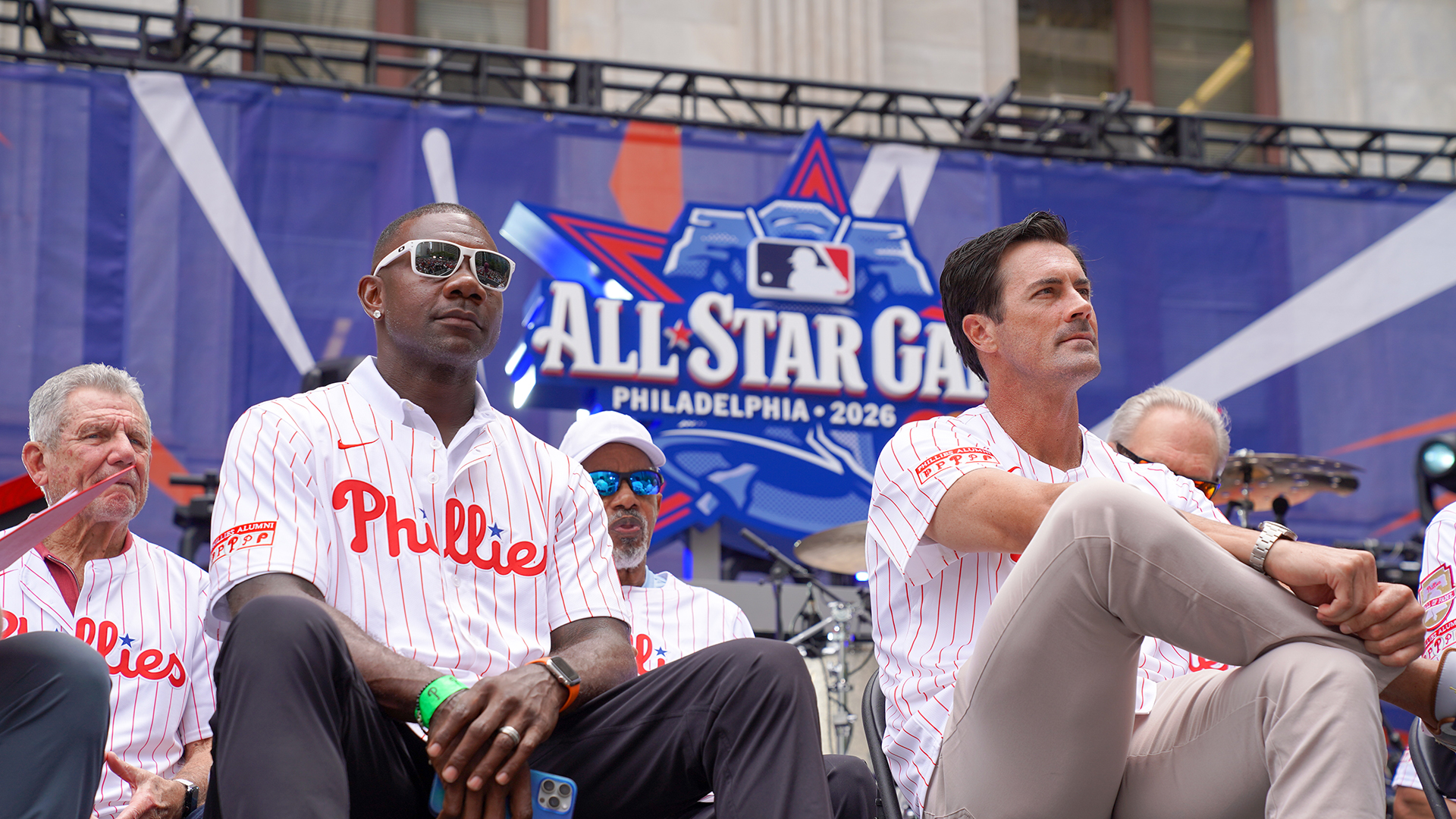 Phillies players sitting on stage with "All Star Game" sign in the background. 