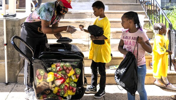 Ice cream bar vendor serves two children