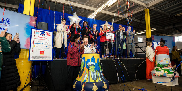 people on stage clapping as confetti falls