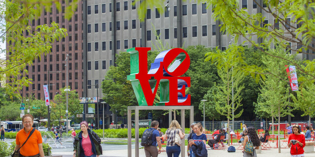LOVE statue at LOVE Park with people near.