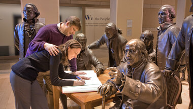 Folks posing with statues of Founding Fathers at National Constitution Center