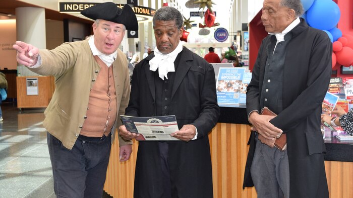 Three historical reenactors at Visitor Center Desk