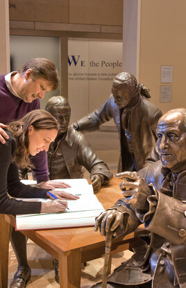 Folks posing with statues of Founding Fathers at National Constitution Center