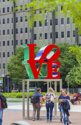 LOVE statue at LOVE Park with people near.